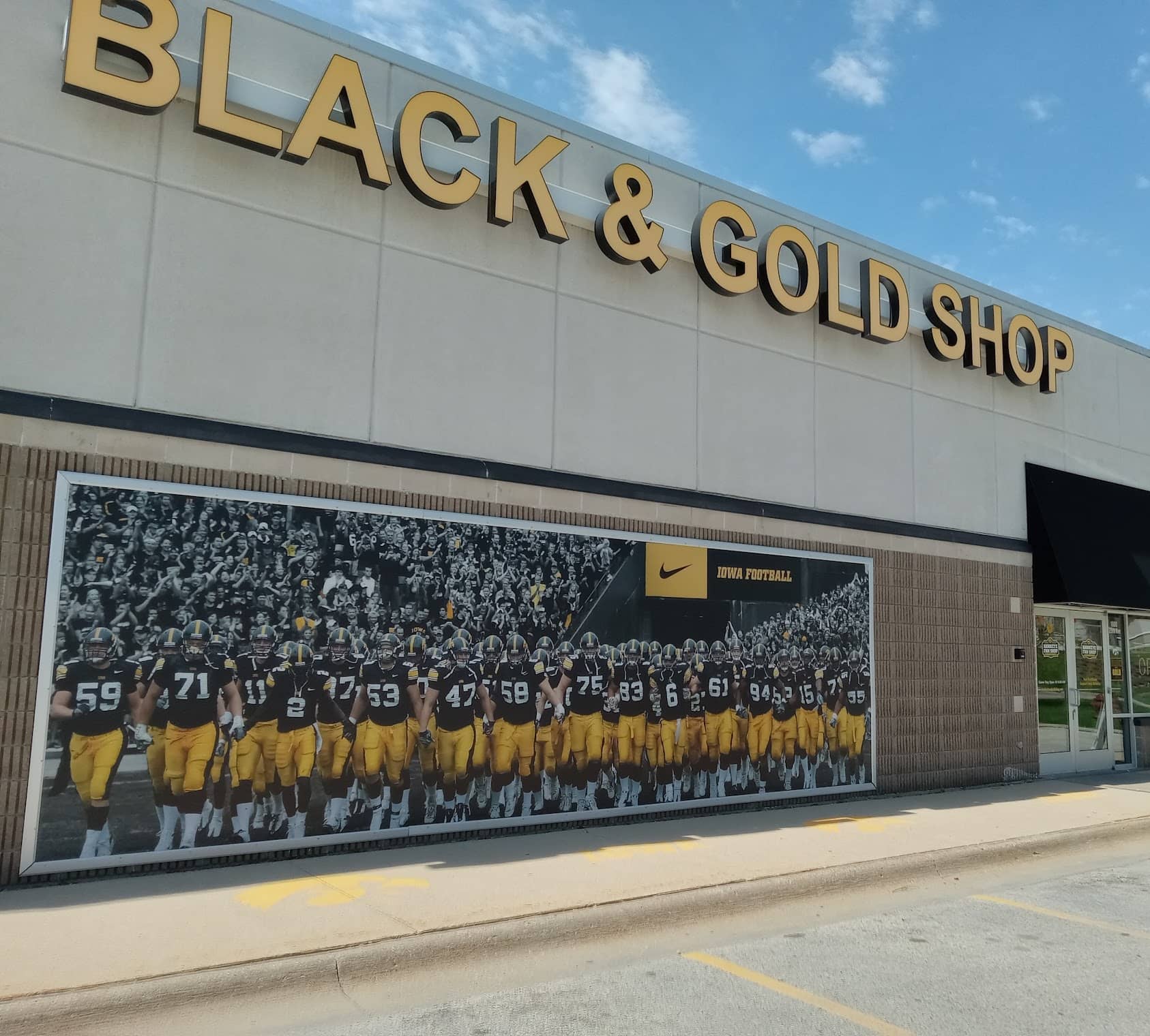 Black & Gold Shop exterior with a large Iowa Hawkeyes football team mural, Coralville Iowa retail location and Scott Labz case study client