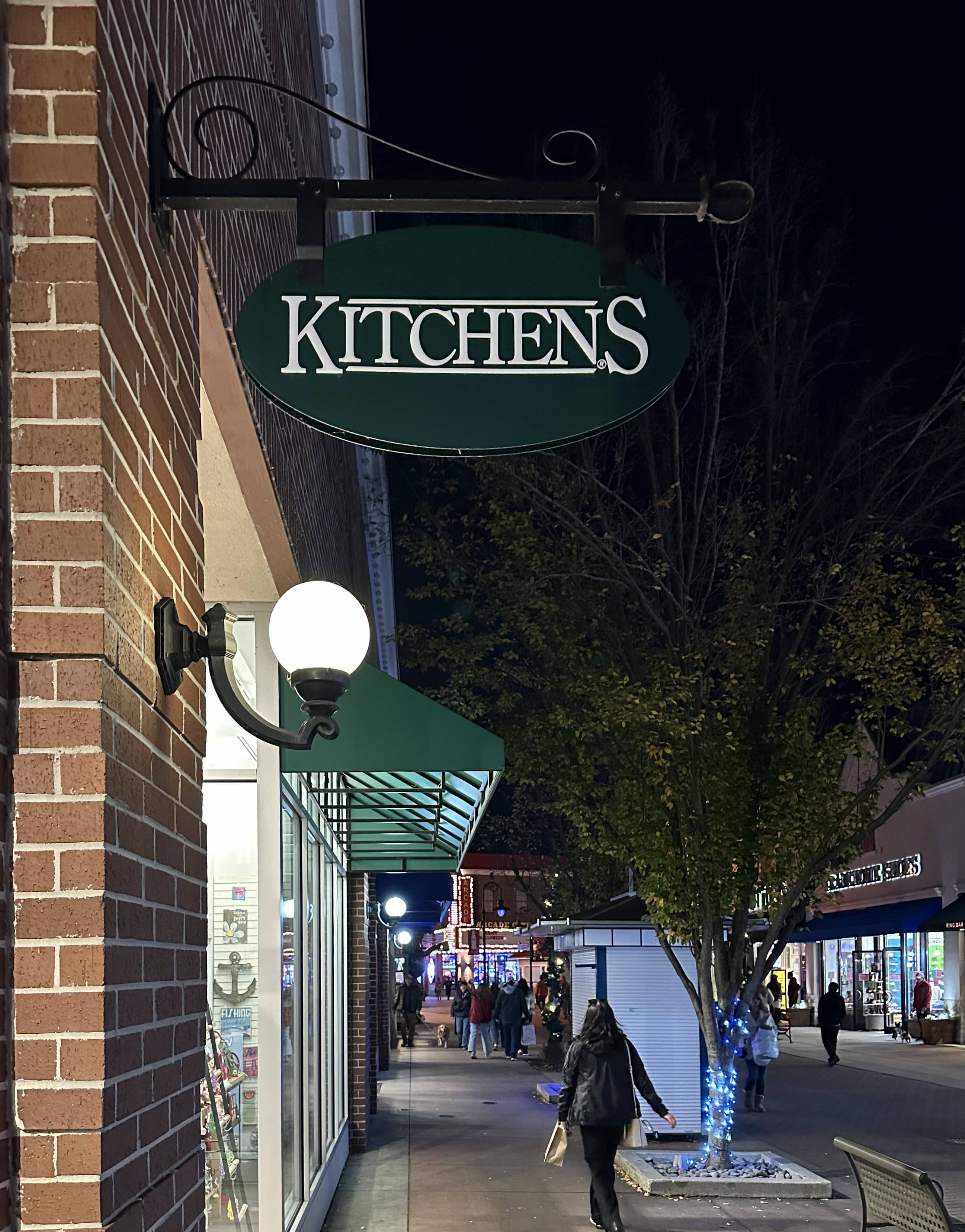 Kitchens storefront sign along a lit shopping district street at night, a long-standing Scott Labz web development and analytics client