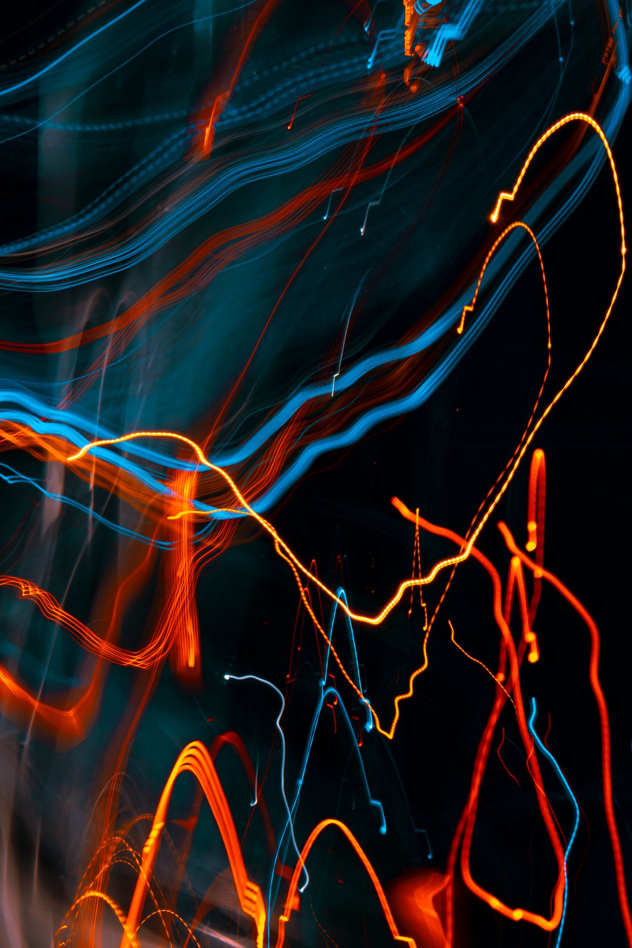 Tangled orange and blue light trails crossing paths, representing automated processes running alongside human judgment